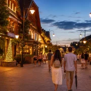 Visitantes caminham por rua iluminada de Gramado durante o Natal Luz no verão