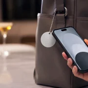Celular próximo a chaveiro NFC em 3D preso a uma bolsa em ambiente corporativo